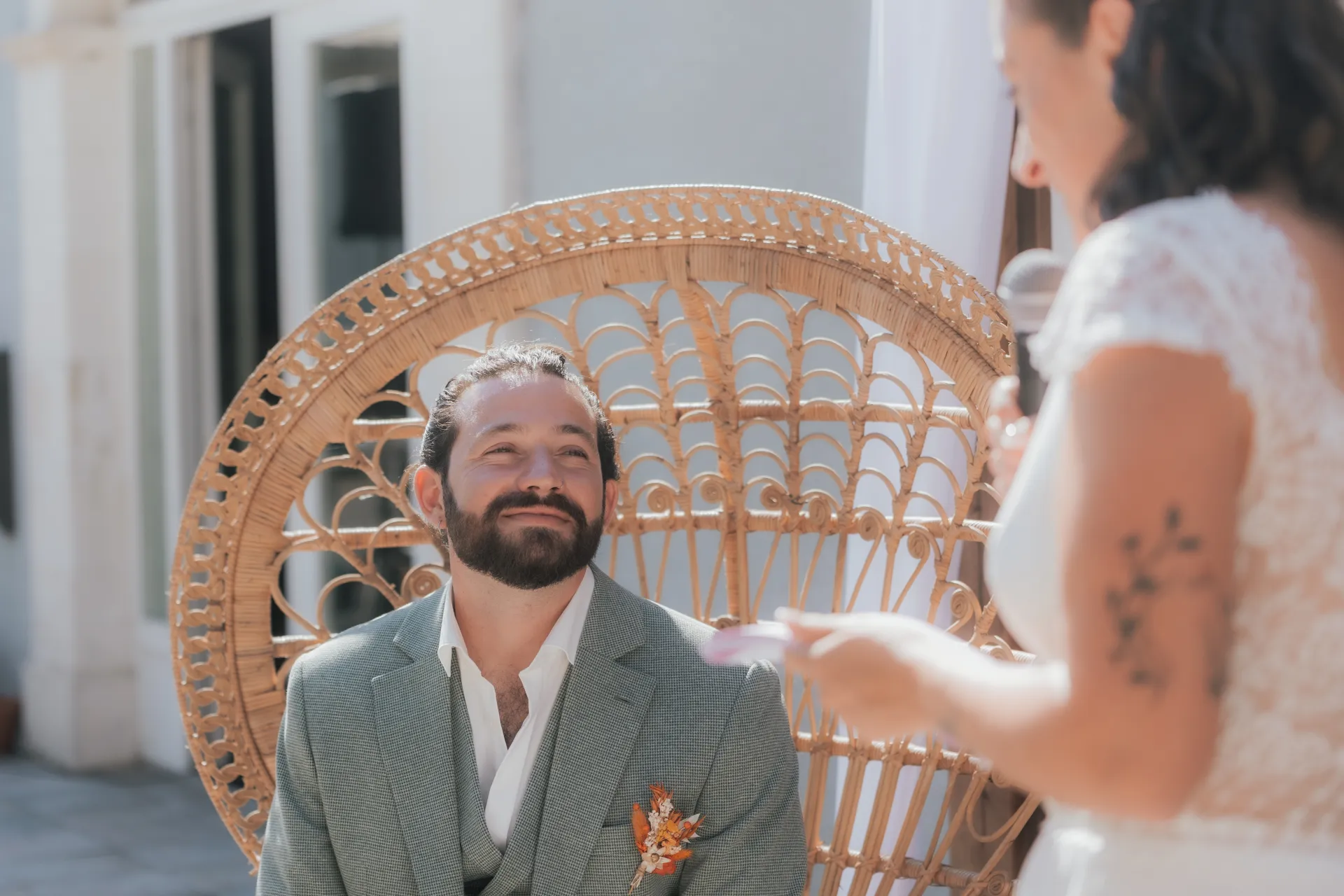 Marié assis sur un fauteuil en rotin à la Villa des 7 Moulins à Lescar, pendant un discours de mariage en lumière douce