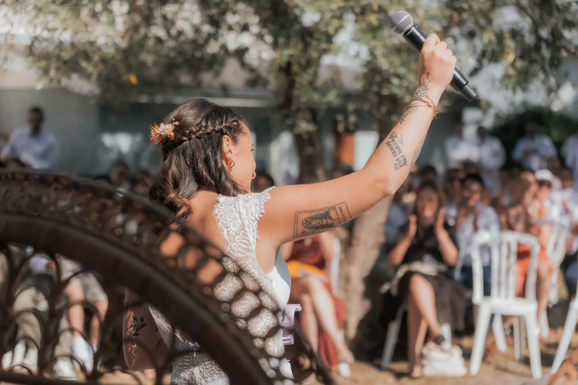 Mariée levant un micro lors d’un mariage à la Villa des 7 Moulins à Lescar, un lieu idéal pour des photos naturelles et lumineuses