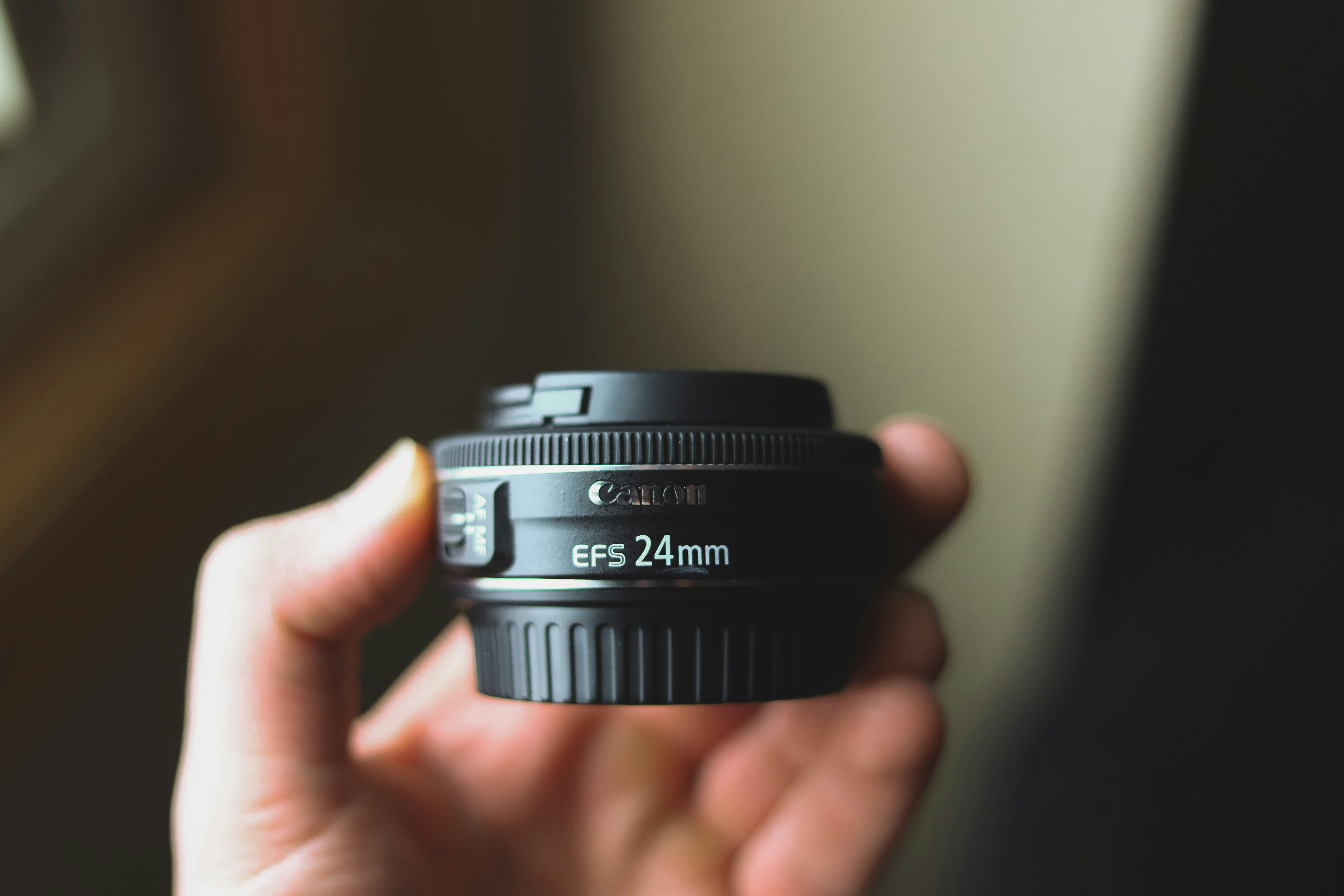 Objectif Canon EF-S 24 mm tenu en main, illustration pour choisir un appareil photo numérique et ses objectifs