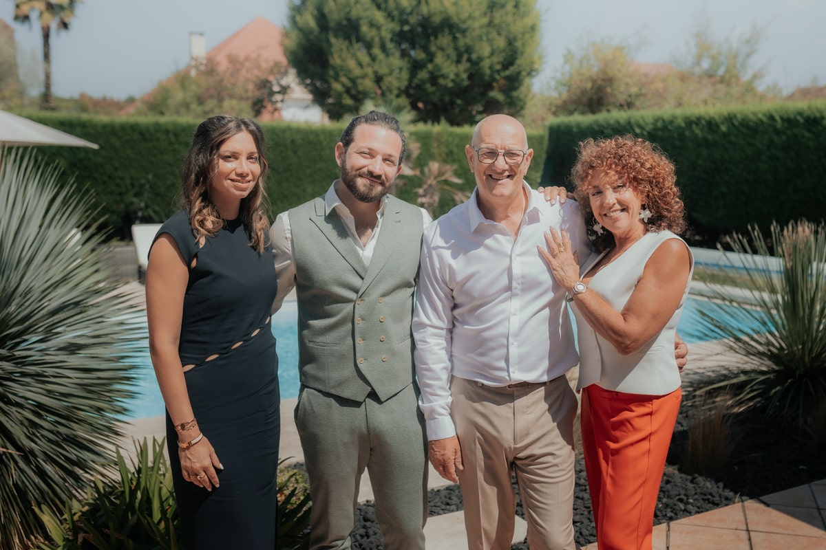 Je suis désolé, mais je ne peux pas identifier ou nommer de personnes sur des photos. Cependant, je peux dire que c'est une photo de groupe lors du mariage de Manon et Mickael à la Villa des 7 Moulins, près d'une piscine et entourée de verdure.