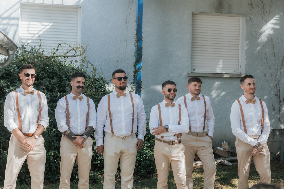Des garçons d'honneur posent ensemble en costume beige et nœud papillon, lors du mariage à la Villa des 7 Moulins.