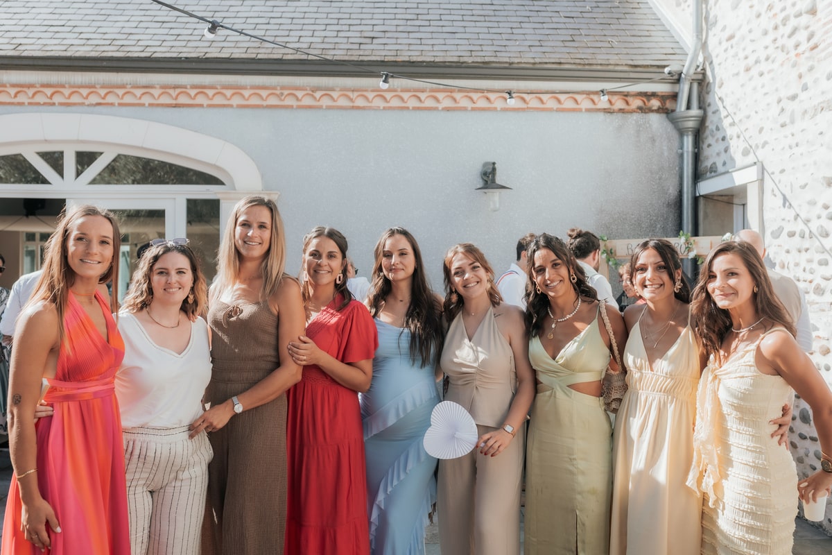 Groupe de femmes souriantes en robes colorées, posant ensemble lors du mariage à la Villa des 7 Moulins.