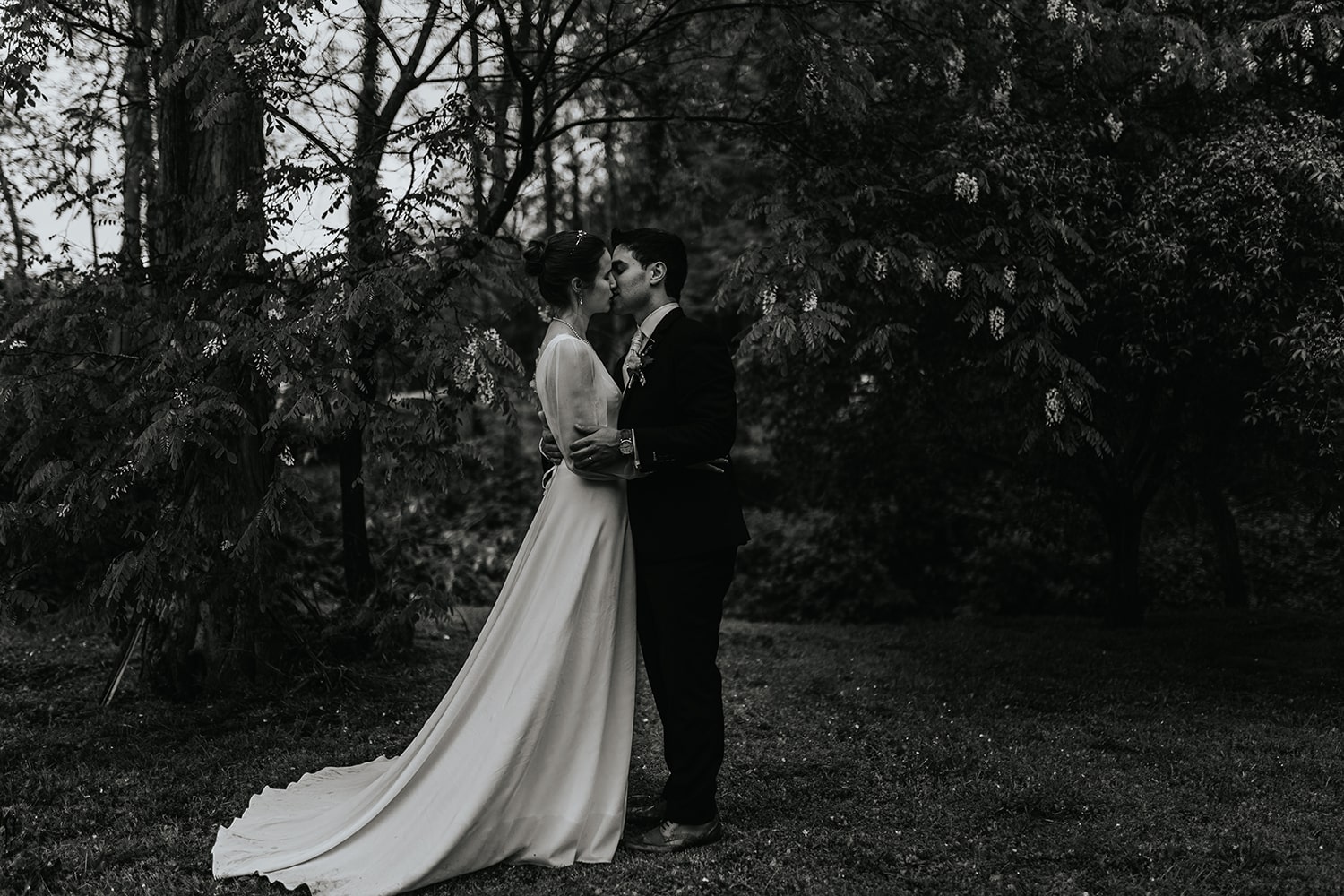 Photographie en noir et blanc du couple dans la forêt s'embrassant - Photographe mariage pau