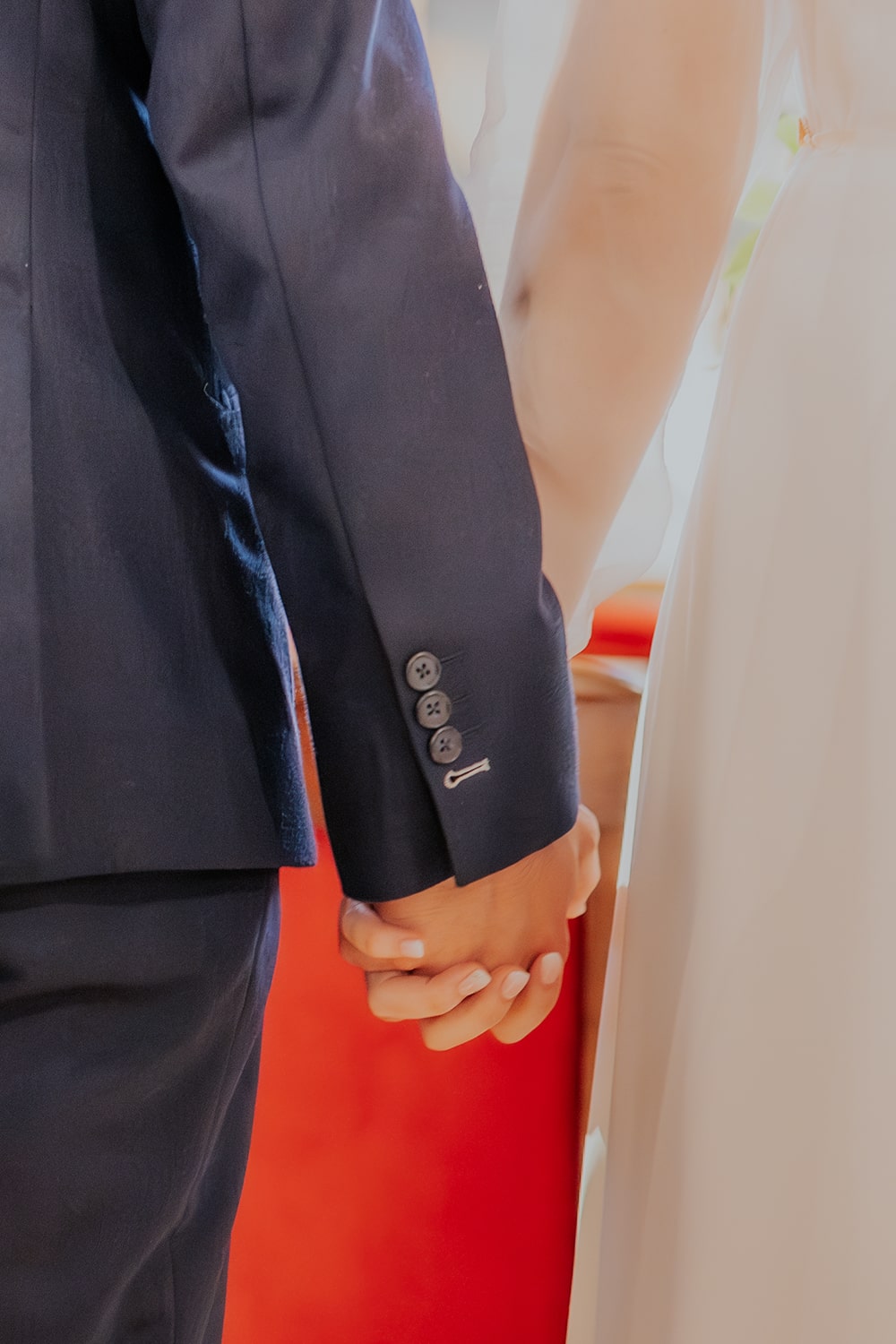 Détail des mariés dans l'église qui se tiennent main dans la main - Photographie mariage pau